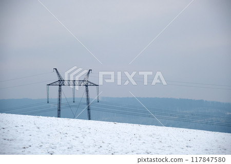 High voltage tower with electric power lines transfening electrical energy through cable wires 117847580