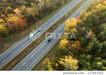 Highway road in North Carolina Appalachian mountains in fall season. Expressway lanes for fast passing of car traffic Highway road in North Carolina Appalachian mountains in fall season. Expressway lanes for fast passing of car traffic 117847582