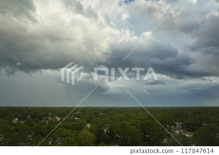 Landscape of dark ominous clouds forming on stormy sky before heavy thunderstorm over rural town area Landscape of dark ominous clouds forming on stormy sky before heavy thunderstorm over rural town area 117847614