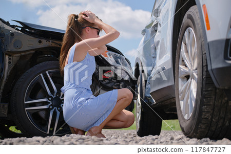 Stressed woman driver standing on street side shocked after car accident. Road safety and insurance concept 117847727