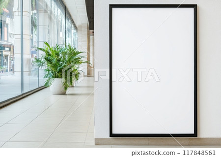 A large, empty black-framed poster for advertisement is prominently placed in a well-lit indoor setting 117848561
