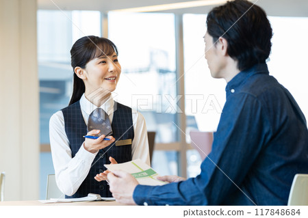 A businesswoman explaining to a middle-aged man. Photo courtesy of Denpa Gakuen, Tokyo Electronics College. A businesswoman explaining to a middle-aged man. Photo courtesy of Denpa Gakuen, Tokyo Electronics College. 117848684