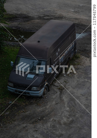 An old, abandoned minibus on the edge of the city, in the evening An old, abandoned minibus on the edge of the city, in the evening 117848799