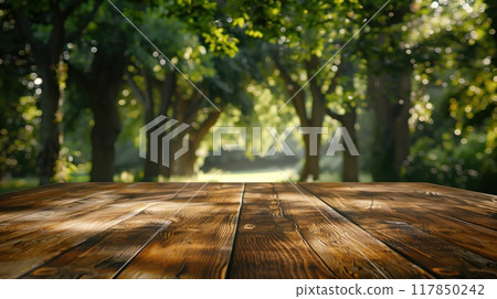Wooden table surface in front of a blurred forest scene during summer, great for environmental campaigns or nature-inspired marketing. 117850242