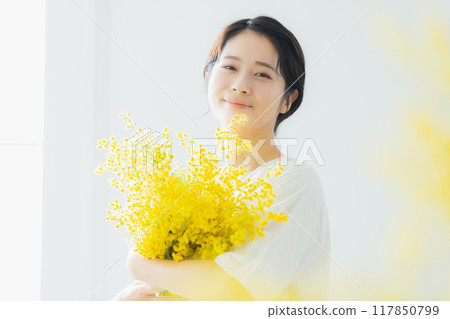 Woman holding a bouquet of mimosa Woman holding a bouquet of mimosa 117850799
