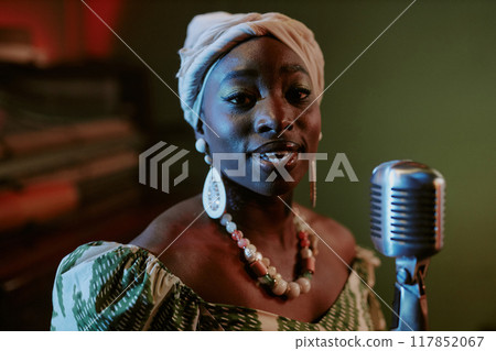 Closeup portrait of young African American woman singing jazz ballad during performance or rehearsal 117852067