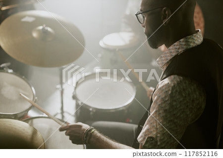 High angle view of young African American musician playing rhythm on drum kit, copy space 117852116