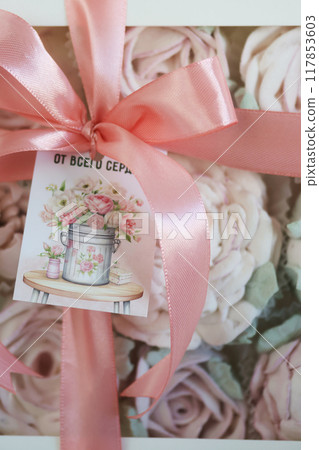 A box of homemade marshmallows. Tied with a ribbon. The tag has the inscription in Russian From the bottom of my heart. Flowers made of marshmallow. Close up. A box of homemade marshmallows. Tied with a ribbon. The tag has the inscription in Russian From the bottom of my heart. Flowers made of marshmallow. Close up. 117853603