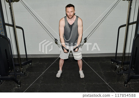 High angle shot of exhausted man doing finish reps, he sweaty and suffering from muscle burning 117854588