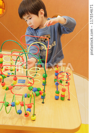 A boy playing with a toy A boy playing with a toy 117854671