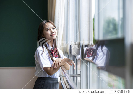 A high school girl looking out the window in the classroom 117858156