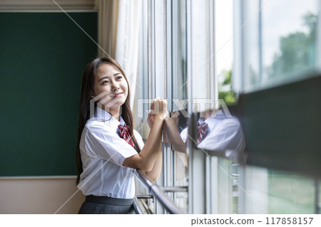 A high school girl looking out the window in the classroom 117858157