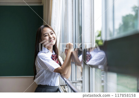 A high school girl looking out the window in the classroom 117858158