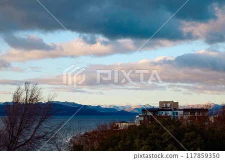 Evening sky over lake, trees and houses Evening sky over lake, trees and houses 117859350