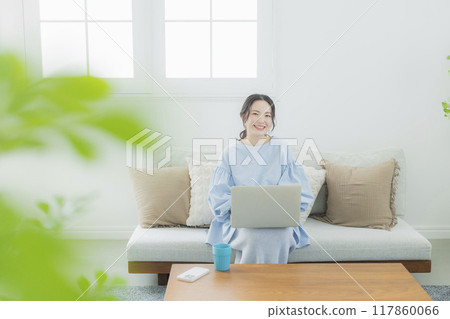 一位女士在客廳使用電腦 117860066