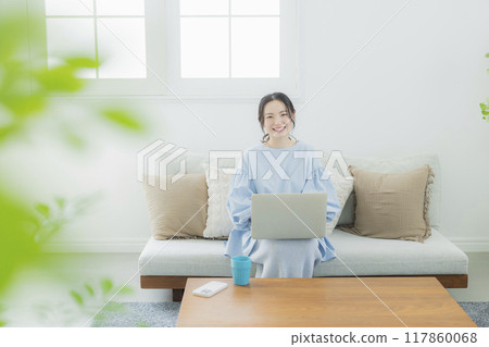 一位女士在客廳使用電腦 117860068