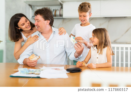 Father gives pocket money to children and wife 117860317