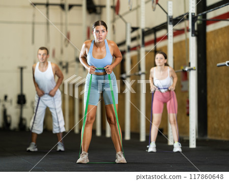 Young woman exercising with elastic band 117860648