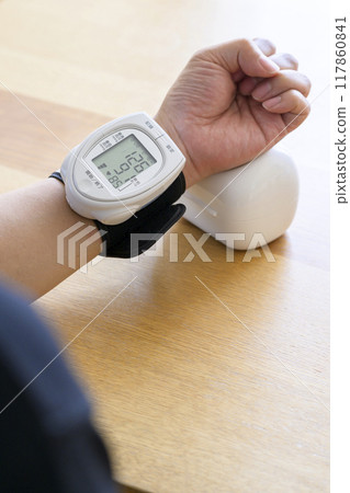 Man measuring blood pressure at home 117860841