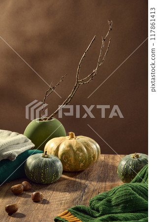 Rustic style photo with autumn concept was taken from high angle on wooden table top, which displaying autumn vegetables like pumpkin and chestnut, sweaters and dry tree branch Rustic style photo with autumn concept was taken from high angle on wooden table top, which displaying autumn vegetables like pumpkin and chestnut, sweaters and dry tree branch 117861413