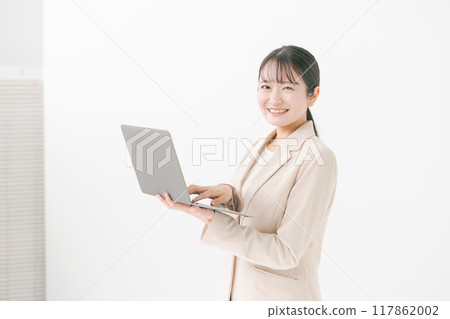 A woman in her twenties holding a computer 117862002