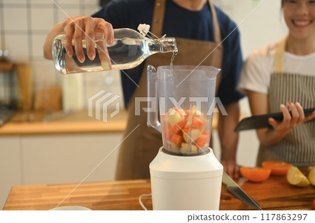 Cropped shot of adult man making healthy Cropped shot of young couple making healthy smoothie on kitchen counter. on kitchen counter Cropped shot of adult man making healthy Cropped shot of young couple making healthy smoothie on kitchen counter. on kitchen counter 117863297