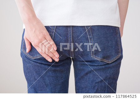 Woman putting her hands on her buttocks Woman putting her hands on her buttocks 117864525