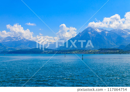 View of the Annecy lake surrounded by beautiful mountains in Annecy, France View of the Annecy lake surrounded by beautiful mountains in Annecy, France 117864754
