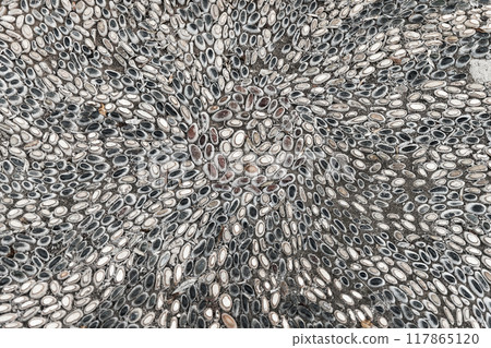 Mosaic ground pavement with radial pattern of black and white pebble stones 117865120