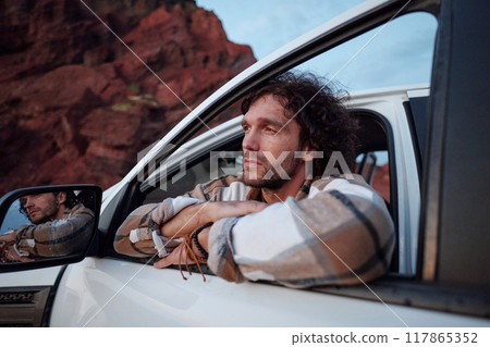 Backpacker by open door of pickup truck 117865352