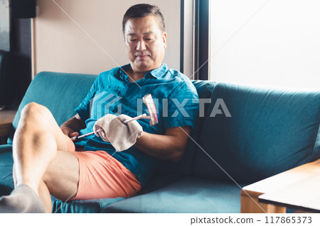 一個男人在客廳照顧高爾夫球桿 117865373