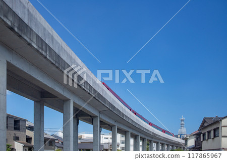 A red train running on an elevated track near Oita Station 117865967