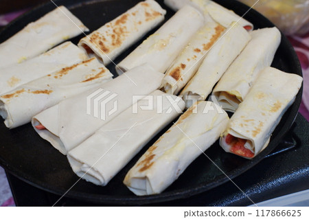 pancakes stuffed with meat and cheese in a frying pan. pancakes stuffed with meat and cheese in a frying pan. 117866625