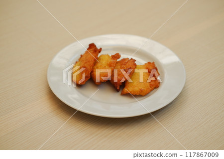 Corn croquettes on a white plate on a wooden table 117867009
