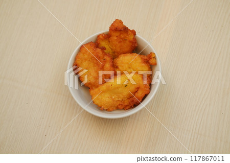Corn croquettes in a bowl on a wooden table 117867011