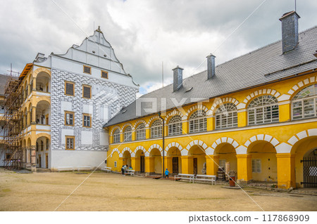 Charming courtyard of Velke Losiny Chateau in Czechia, surrounded by picturesque architecture and history, while the clouds hint at a change in weather. 117868909