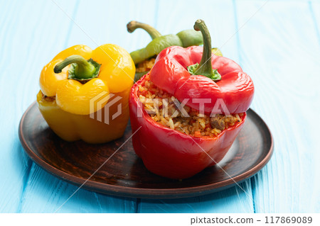 Baked stuffed pepper ( paprika ) with rice , carrot and meat . Top view on rustic background Baked stuffed pepper ( paprika ) with rice , carrot and meat . Top view on rustic background 117869089
