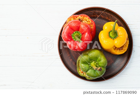 Baked stuffed pepper ( paprika ) with rice , carrot and meat . Top view on rustic background Baked stuffed pepper ( paprika ) with rice , carrot and meat . Top view on rustic background 117869090