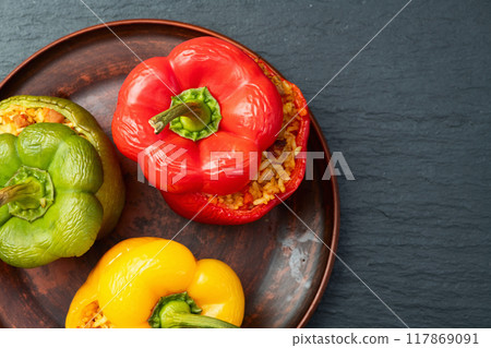 Baked stuffed pepper ( paprika ) with rice , carrot and meat . Top view on rustic background Baked stuffed pepper ( paprika ) with rice , carrot and meat . Top view on rustic background 117869091