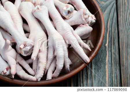 Raw chicken foot ( paws ) Top view on rustic background 117869098