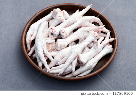 Raw chicken foot ( paws ) Top view on rustic background 117869100