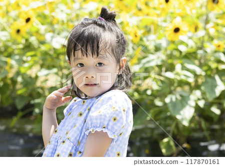 girl playing in a sunflower field 117870161