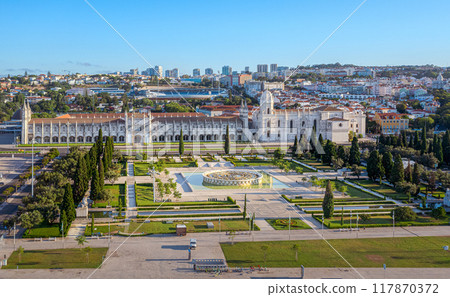 Aerial view of Jeronimos Monastery and Santa Maria de Belem church and Empire square garden with fresh foliage and large fountain in center, Lisbon, Portugal, on sunny day with clear blue sky. UNESCO Aerial view of Jeronimos Monastery and Santa Maria de Belem church and Empire square garden with fresh foliage and large fountain in center, Lisbon, Portugal, on sunny day with clear blue sky. UNESCO 117870372