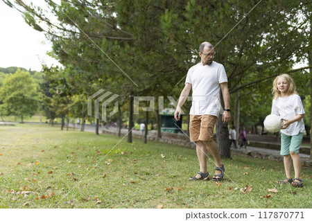 Father and daughter walking in park with volleyball Father and daughter walking in park with volleyball 117870771