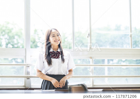 Portrait of a high school girl by the window in the classroom 117871206