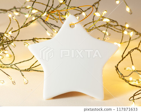 Ceramic Christmas decoration. Christmas ornament on the Christmas lights background. 117871633