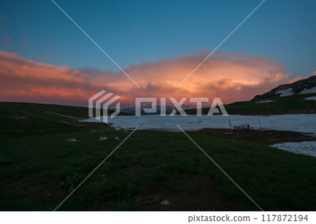 Mountain Sunset Over a Snowy Meadow Mountain Sunset Over a Snowy Meadow 117872194