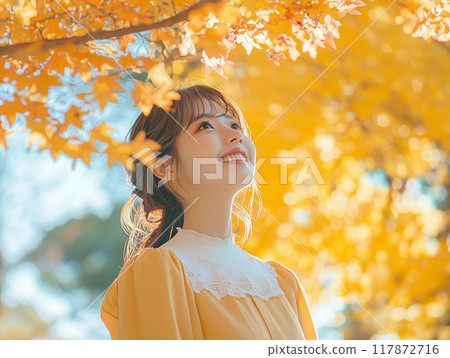 A woman looking at autumn leaves A woman looking at autumn leaves 117872716