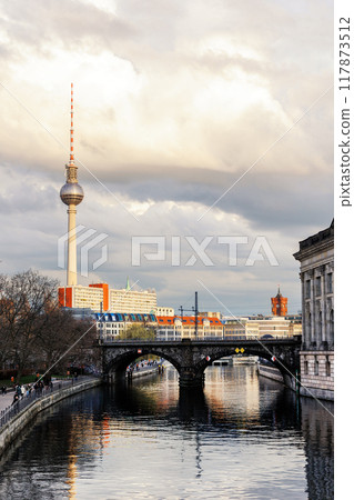 Scenic Berlin Mitte view S-bahn bridge over River Spree Bode Museum TV Tower and historic  buildings in center district on a cloudy overcast sky sunset evening. Urban german capital cityscape scene 117873512
