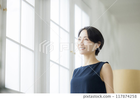 Middle-aged woman in the living room Middle-aged woman in the living room 117874258